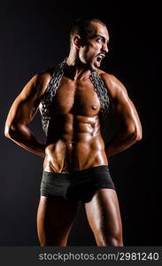 Muscular man with chain on black background