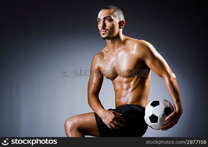 Muscular man with football ball