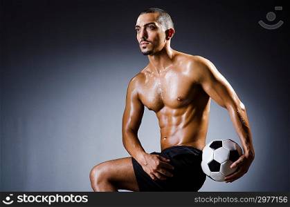 Muscular man with football ball