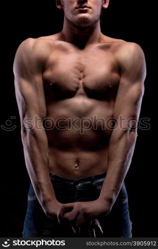 Muscular naked man on black