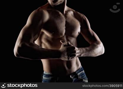Muscular naked man on black. Focus and hands