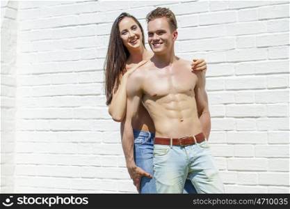 Muscular young man and sexy naked woman, summer outdoors