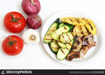 Mushrooms And Grilled Squash. Grilled Zucchini and yellow Summer Squash on a white plate with tomatoes, onions and Garlic