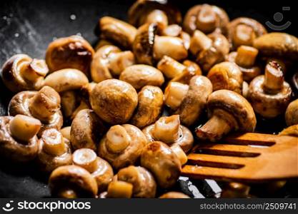 Mushrooms are fried in a frying pan. Macro background. High quality photo. Mushrooms are fried in a frying pan. 