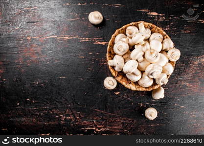 Mushrooms in a basket on the table. Against a dark background. Top view. High quality photo. Mushrooms in a basket on the table.