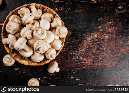 Mushrooms in a basket on the table. Against a dark background. Top view. High quality photo. Mushrooms in a basket on the table.