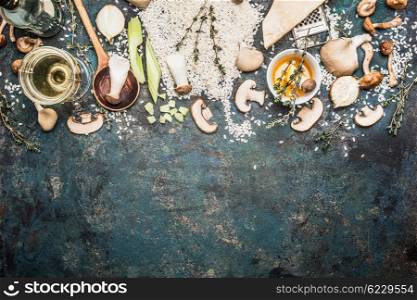 Mushrooms risotto ingredients with cooking spoon on dark rustic background, top view, border. Italian food concept
