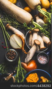 Mushrooms with autumn vegetables and cooking ingredients on dark wooden background, top view