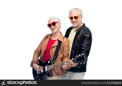 music, age and people concept - happy senior couple in sunglasses with electric guitar. senior couple in sunglasses with electric guitar