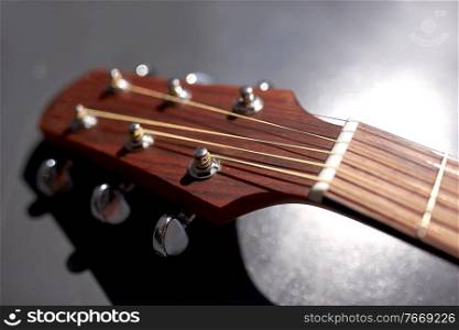 music and musical instruments concept - close up of acoustic guitar head with pegs. close up of acoustic guitar head with pegs
