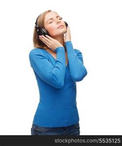 music and technology concept - calm young woman with closed eyes listeting to music with headphones