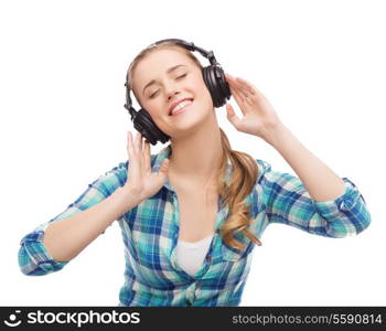 music and technology concept - smiling young woman listening to music in headphones