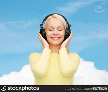 music and technology concept - smiling young woman with closed eyes listening to music with headphones