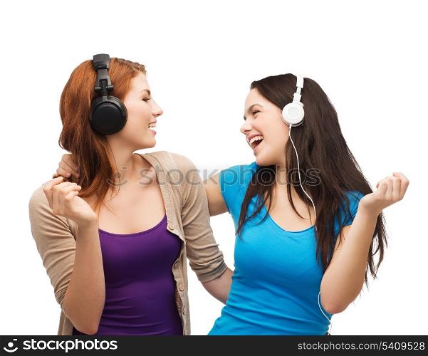 music and technology concept - two laughing teenagers with headphones