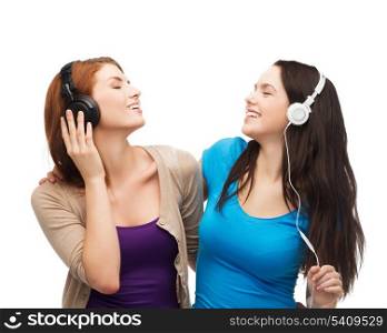 music and technology concept - two smiling teenagers with closed eyes listeting to music with headphones