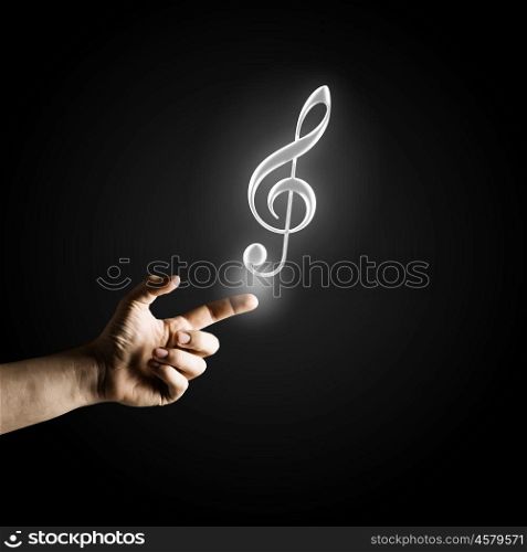 Music concept icon. Male hand pointing with finger at music sign
