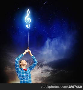 Music concept. Young woman holding music sign on rope