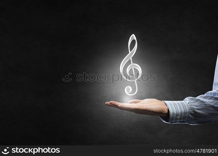 Music icon in hand. Hand of man hold music note icon in palm
