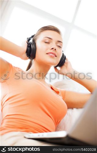 music, internet and shopping - woman with headphones and laptop at home