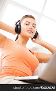 music, internet and shopping - woman with headphones and laptop at home