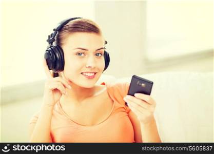 music, internet and shopping - woman with headphones and smartphone at home