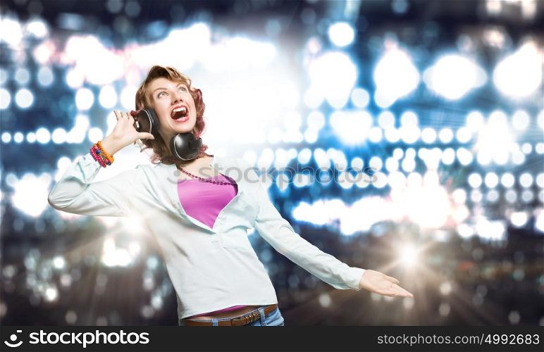 Music is my life!. Young woman wearing headphones against bokeh background