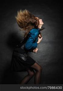 music love passion concept. Young woman with flying long hair dancing. Studio shot on grunge background