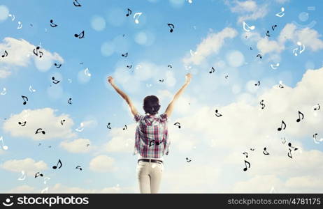 Music lover. Back view of young girl in casual enjoying music