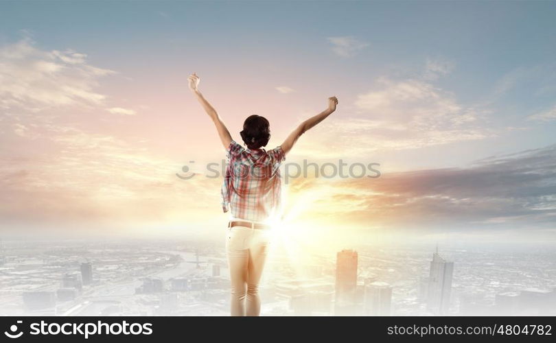 Music lover. Back view of young girl in casual enjoying music