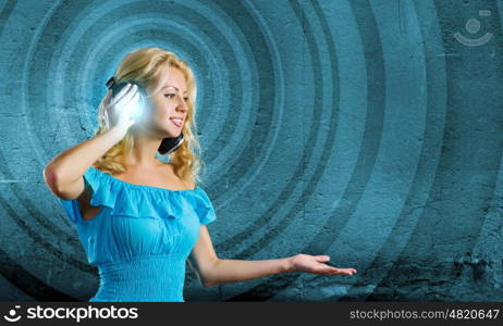 Music lover. Young blond girl in blue dress listening music