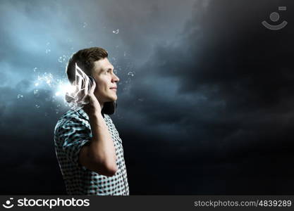 Music lover. Young handsome man in earphones enjoying the music