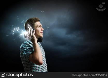 Music lover. Young handsome man in earphones enjoying the music