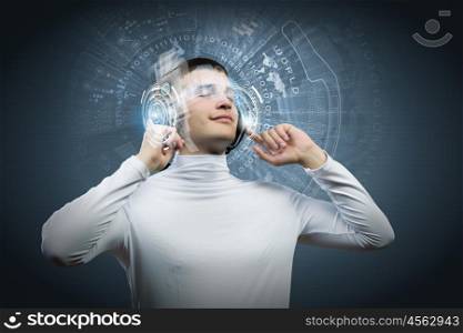 Music lover. Young man wearing headphones against media background. New technologies