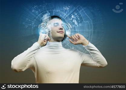 Music lover. Young man wearing headphones against media background. New technologies