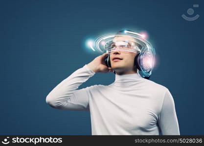 Music lover. Young man wearing headphones against media background. New technologies