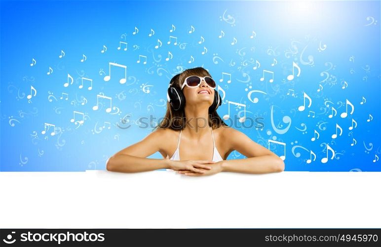 Music lover. Young pretty girl in bikini with blank banner