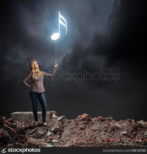 Music lover. Young woman in casual holding balloon shaped like clef