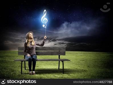Music lover. Young woman in casual holding balloon shaped like clef