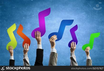 Music note. Group of people hands holding colorful music symbols