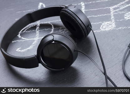 Music notes with headphones . Music notes with treble clef and headphones on black