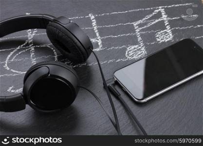 Music notes with treble clef, smartphone and headphones