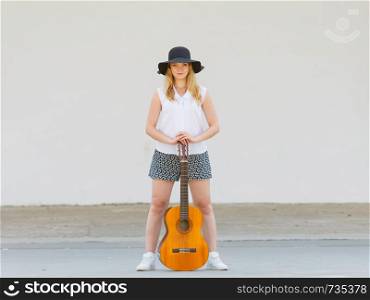 Music, passsion, hobby concept. Woman standing playing on acoustic guitar outside. Woman standing playing on acoustic guitar outside