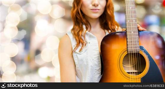 music, people and musical instruments concept - close up of female musician with acoustic guitar over lights background. close up of female musician with guitar