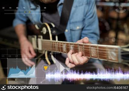 music, people and recording studio concept - close up of male guitarist playing electric guitar and sound frequency diagram. close up of man playing guitar at studio rehearsal