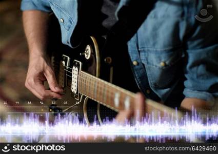 music, people and recording studio concept - close up of male guitarist playing electric guitar and sound frequency diagram. close up of man playing guitar at studio rehearsal