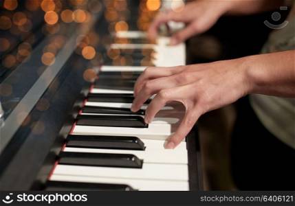 music, people, art, musical instruments and entertainment concept - close up of hands playing piano. close up of hands playing piano