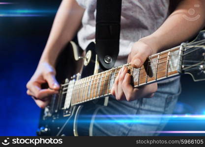 music, people, musical instruments and entertainment concept - close up female musician hands playing electric guitar with mediator