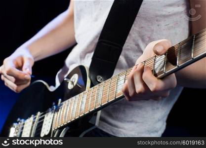 music, people, musical instruments and entertainment concept - close up female musician hands playing electric guitar with mediator