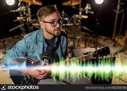 music, people, musical instruments and entertainment concept - male guitarist playing electric guitar at studio rehearsal. musician playing guitar at studio rehearsal