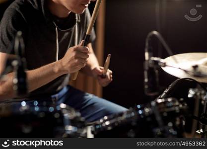 music, people, musical instruments and entertainment concept - male musician playing drums and cymbals at concert or studio. male musician playing drums and cymbals at concert